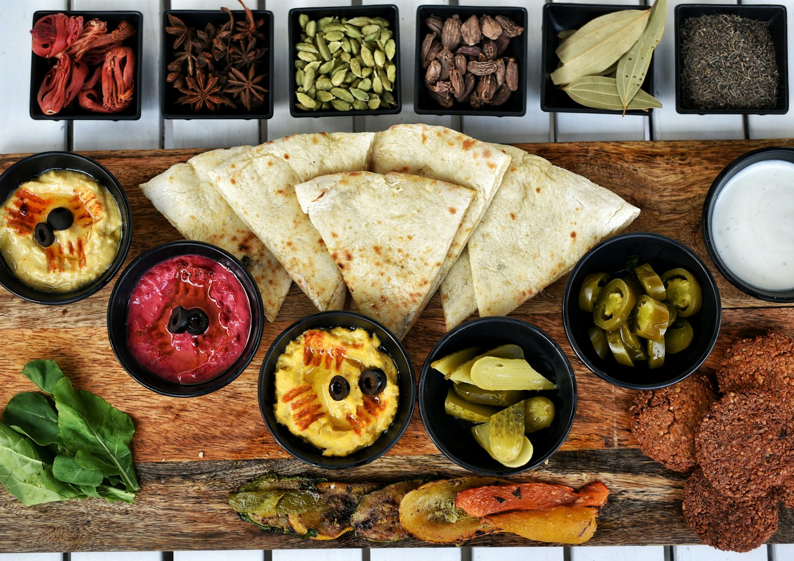 Holzbrett mit Hummus, Dips und Fladenbrot